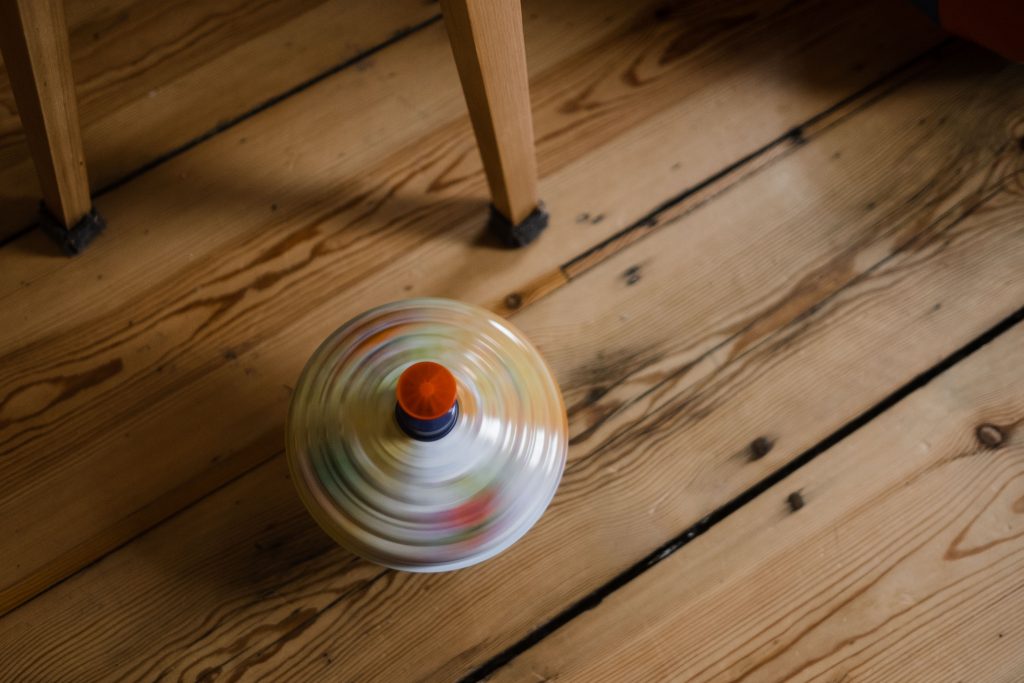 ein Brummkreisel liegt auf einem alten Holzfußboden im Wohnzimmer