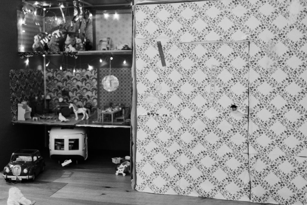 ein Spielhaus, dass tapeziert ist, es steht in einem Kinderzimmer, die Tür ist geschlossen