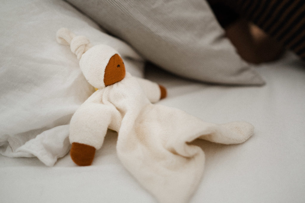 in einem Bett im Schlafzimmer liegt eine weiße 