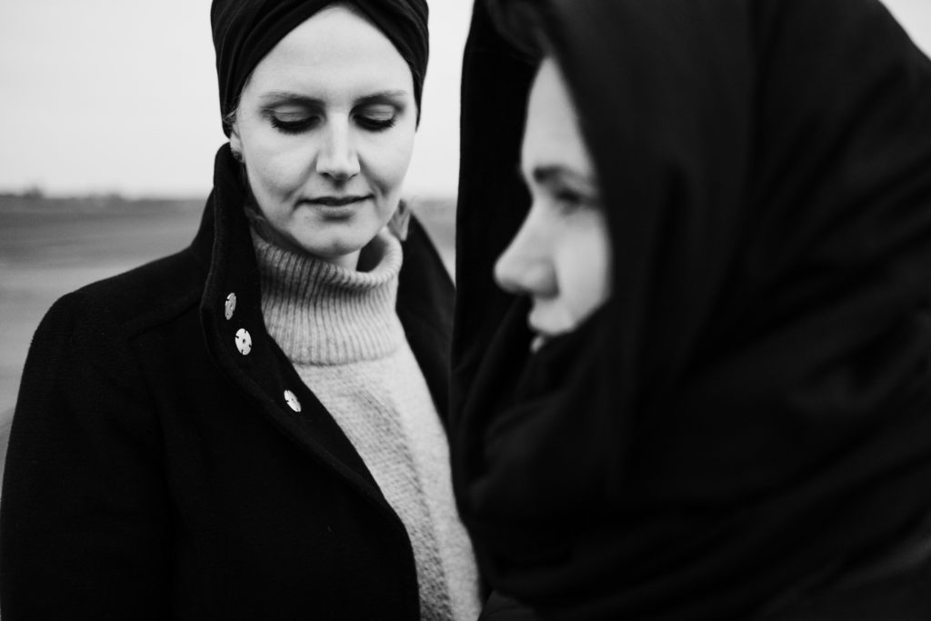 auf dem alten Rollfeld des Flughafen in Berlin stehen 2 Frauen, eine Frau schaut nach untern, die andere Frau schaut nach vorne